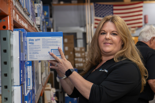 Jessica Dulin, MCS's President and CEO, prepares a box of copy paper and other printer supplies for Ann Arbor's nonprofits.