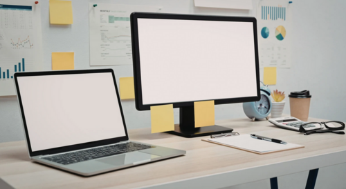 A workstation with a business laptop and desktop on the top.
