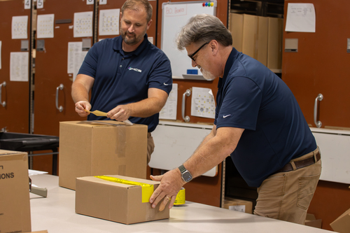 Employees at MCS packing orders of ink and toner for their customers.